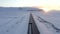 Aerial: close up of jeep driving on Iceland Road with Snow white Mountains and Sunset Snow, Arctic