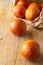 Aerial closeup of blood oranges in paper bag, with selective focus, on rustic wooden table