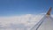 Aerial clouds view from inside airplane window. Airplane flying and turning over clouds. Plane and transportation concept
