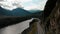 Aerial cloudy day view automobile road near river surrounded cliff mountains