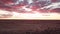 Aerial, cloudy purple sunset over arid Australian outback desert landscape