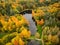 Aerial colorful forest scene in autumn with orange and yellow foliage.