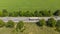 Aerial. Commercial truck driving by the roadway along the agricultural field