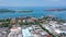 Aerial container terminal of Benoa Harbour with stacks of the boxes and a red command tower under light blue sky