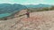 Aerial: couple hiking on the mountains, backpackers walking outdoors panoramic view, inspiring travel and freedom, drone flight re