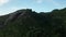 Aerial crane over Baie Ternay beach to top of rock with huge boulders