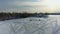 Aerial crane shot coming down over the frozen lake in Laval-Ouest at sunset with someone walking in the white snow of winter