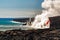 Aerial daytime view of fire hose waterfall shaped flow of red lava from volcano in Hawaii exploding into the turquoise sea