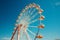 Aerial delight Ferris Wheel rotates against the vivid blue sky