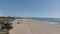 Aerial descending footage of wide sand beach in city. Santa Monica Beach on sunny day. Los Angeles, California, USA