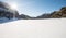 Aerial of Diga del Fedaia on the Fedaia Pass in winter. Frozen Lake covered in Snow at the feet of the Marmolada