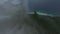 Aerial dive from mountain top rainforest fog tropical island at sea landscape lagoon