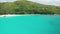 Aerial dolly over the emerald water of lagoon and white yacht, Praslin