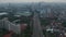 Aerial dolly tilt shot following cars on a multi lane highway and revealing wide view of modern urban city skyline of