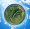 Aerial drone 360 degree view on wind turbine, snake shape road, wheat fields and forest during summer