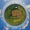 Aerial drone 360 degree view on wind turbine, snake shape road, wheat fields and forest during summer