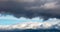 Aerial, drone dark clouds on blue sky over mountains background