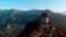 Aerial: drone flying at old medieval abbey perched on mountain top, background snowy Alps at sunrise. Sacra di San Michele italia