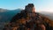 Aerial: drone flying at old medieval abbey perched on mountain top, background snowy Alps at sunrise. Sacra di San Michele italia