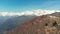 Aerial: drone flying over forest in springtime, aerial view of snow capped mountain range and valley on the Alps, clear blue sky,