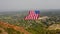 Aerial Drone Flying Right Past American Flag Hung Between Mountain Cliffs