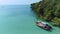 AERIAL. Drone flying under the amazing tropical bay with clear water, white beach and traditional longtail boats