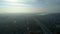 Aerial drone footage. Fly over autobahn near downtown with city on horizon in light fog.