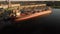 Aerial drone footage of a industrial grain elevator and a cargo ship being loaded in the port of Vancouver at sunset. 4K