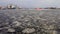 Aerial drone footage of international cargo harbor on melting ice with ships and terminal cranes on pier and steel grain
