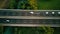 Aerial drone footage. Long haul semi trucks driving on the busy highway in the rural region of Italy. Agricultural crop