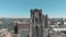 Aerial drone footage rising along the face of a church tower, revealing the city of Rotterdam, Netherlands.