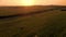 Aerial drone footage in a sunset light over the meadow with bales