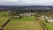 Aerial drone footage of the town of Huddersfield in West Yorkshire, England showing old cottages and a farmers field with animals