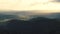 Aerial Drone Footage View: Flight over mountains with forests, meadows and hills in sunset soft light. Carpathian