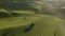 Aerial drone footage view: flying over spring mountains, hills and meadows with pine forests in sun soft light. Europe