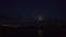 Aerial drone futage. Moonlit night over the city on the sea or ocean