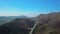 Aerial drone over countryside and long winding road, California, USA. fly to up