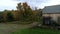 Aerial Drone - Pan Past Old Barn Towards Vibrant Colored Trees in Fall in Vermont 4K.