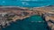 Aerial drone Panorama of picturesque bay in Malta called Popeye village, former movie set and now a beautiful beach with houses