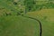 Aerial drone perspective view on european green meadows and forest divided by snake like river