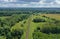 Aerial drone perspective view on straight curved railroad in rural scenery with green forest during summer