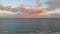 Aerial drone point of view picturesque landscape horizon over calm Mediterranean Sea pink grey colourful fluffy clouds during