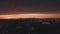 Aerial: drone rising up overlooking Brooklyn with Manhattan Skyline in Background in Dark Orange Dawn Light