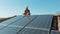 Aerial drone - Safe Worker installing photovoltaic panel on domestic home rooftop