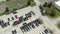 Aerial drone shot of the car carrier trailer car hauler loads cars on the trailer, on parking of the dealer lot