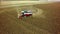 Aerial drone shot of a combine harvester working in a field. Tractors and farm machines harvesting corn in Autumn