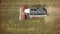 Aerial drone shot of a combine harvester working in a field. Tractors and farm machines harvesting corn in Autumn