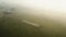 Aerial drone shot of a cricket pitch, cricket players playing cricket early in the morning in fog in New Delhi