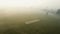 Aerial drone shot of a cricket pitch, cricket players playing cricket early in the morning in fog in New Delhi