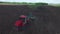 Aerial drone shot of a farmer in tractor seeding,